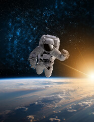 Astronaut in outer space over the planet Earth.Stars provide the background.erforming a space above planet Earth.Sunrise,sunset.Our home. ISS.Elements of this Image Furnished by NASA.