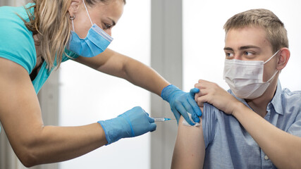 Vaccination concept. Nurse's hands holding injection and cotton tampon before make injection to...