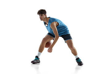 Full length portrait of basketball player practicing isolated on white studio background. Tall muscular athlete dribbling the ball.