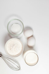 Baking homemade bread on white kitchen worktop with ingredients for cooking, culinary background, copy space, overhead view