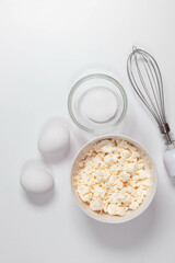 Baking ingredients on a white table. White eggs, flour, sugar and spices. Home concept for baking, baking cake or biscuit ingredients