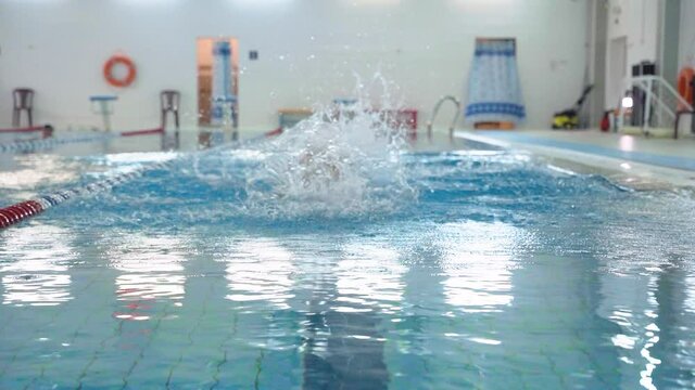 Amature sportsman swims butterfly technique in indoor lap pool and preparing for competition. Front view video showing endurance, sport, professional swimming slow motion