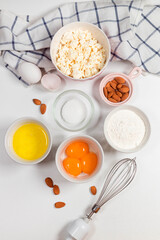 Baking utensils and cooking ingredients for a tarts, cookies, dough and pastry. Flat lay with eggs, flour, sugar, cottage cheese