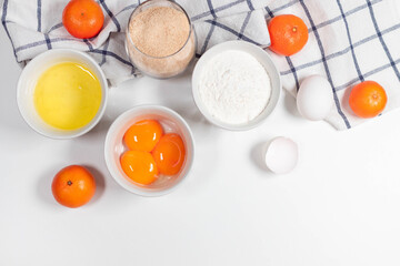 Baking ingredients on a white table. White eggs, flour, sugar. Home concept for baking, baking cake or biscuit ingredients
