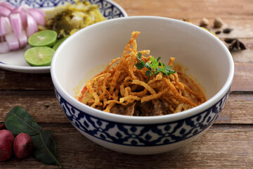 Local northern Thai food Egg noodle curry with beef on wood background