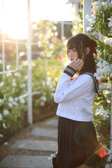 Asian school girl walk and looking with flower garden background