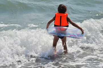 A girl is bathing in a life jacket