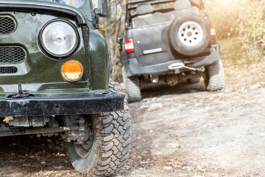 Pair of two old retro vintage 4x4 soviet suv vehicle on dirt gravel unpaved road in summer at sunset morning sun. Off road car mountain safari adventure nature trip journey concept. ATV rental . - Powered by Adobe