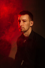 male portrait in red light with smoke.