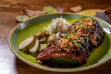 Elegant and delicious food on restaurant. Plate with tasty meal on the wooden table. Gourmet cuisine, lunch, dinner, beautiful, modern. Grilled pork ribs with spices