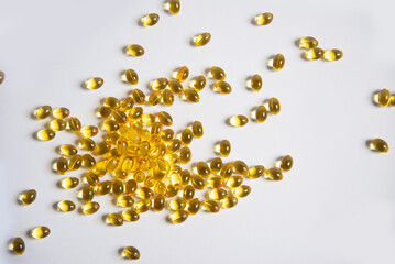 White background from tablets of gelatinous golden yellow capsules, vitamin D3. Beautiful colored golden vitamin D3 tablets, background, nutrition, nutritional supplements. A bunch of vitamin D3.