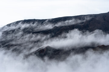 Volcanic landscape shrouded in mist, creating a mysterious atmosphere in La Réunion.