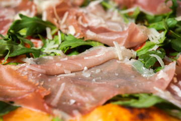 Delicious pizza close up, white plate on black background