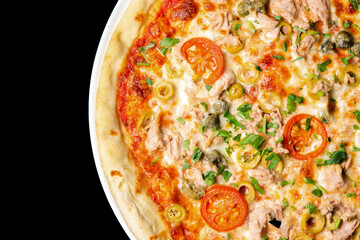 Delicious pizza close up, white plate on black background