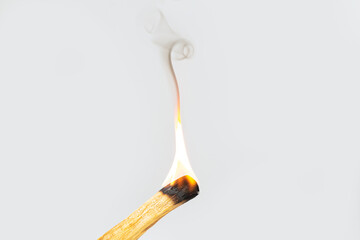 Palo santo or holy wood incense stick burning with flame and aromatic smoke