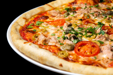 Delicious pizza close up, white plate on black background