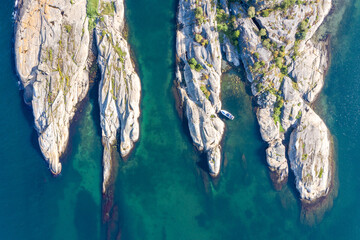 Aerial shot of a narrow fjord with turquoise waters surrounded by cliffs in Norway.