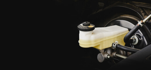 Brake fluid reservoir of car brake system with horizontal copy space on black background - obrazy, fototapety, plakaty
