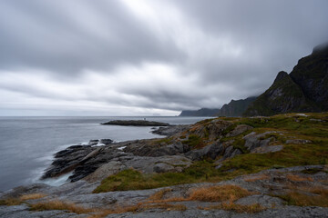 Obraz premium Overcast coastline in the Lofoten Islands, Norway, with dramatic cliffs meeting the sea.