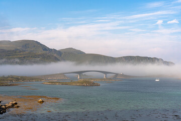 A series of bridges in Lofoten, enveloped in morning mist, connects the scattered islands, creating a mystical pathway through the Norwegian archipelago