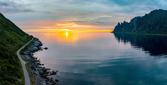 Empty asphalt road on edge of the arctic sea hit by the midnight sun, Ersfjord, Senja, Troms county, Norway, Scandinavia
