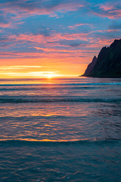 Burning sky of midnight sun reflecting in the sea, Ersfjord, Senja, Troms county, Norway, Scandinavia