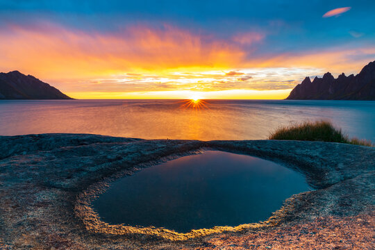 Ersfjord and Steinfjord fjords lit by midnight sun from rock formation at Tungeneset viewpoint, Senja, Troms county, Norway, Scandinavia