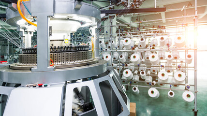 Textile industry - yarn spools on spinning machine in textile factory - Powered by Adobe