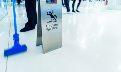 Cleaning in progress with wet floor caution sign besides