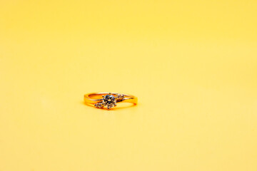 Solitaire engagement ring round cut yellow background	