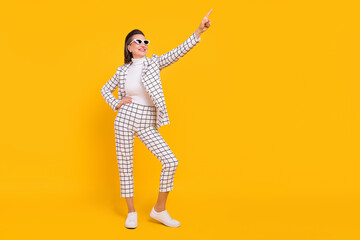 Full size portrait of attractive cheerful aged lade arm on waist indicate finger empty space isolated on yellow color background