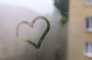 Heart drawn on foggy window. Rainy weather