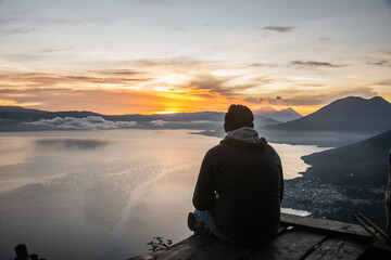 Naklejka na ściany i meble Tourist enjoying the sunrise from La Rostra Maya, Lake Atitlan, Guatemala