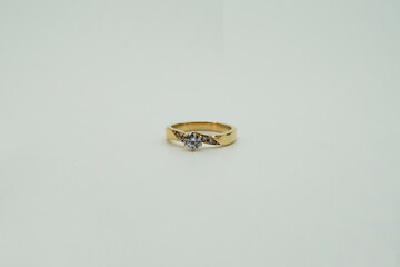 gold ring surrounded by diamonds on white background	