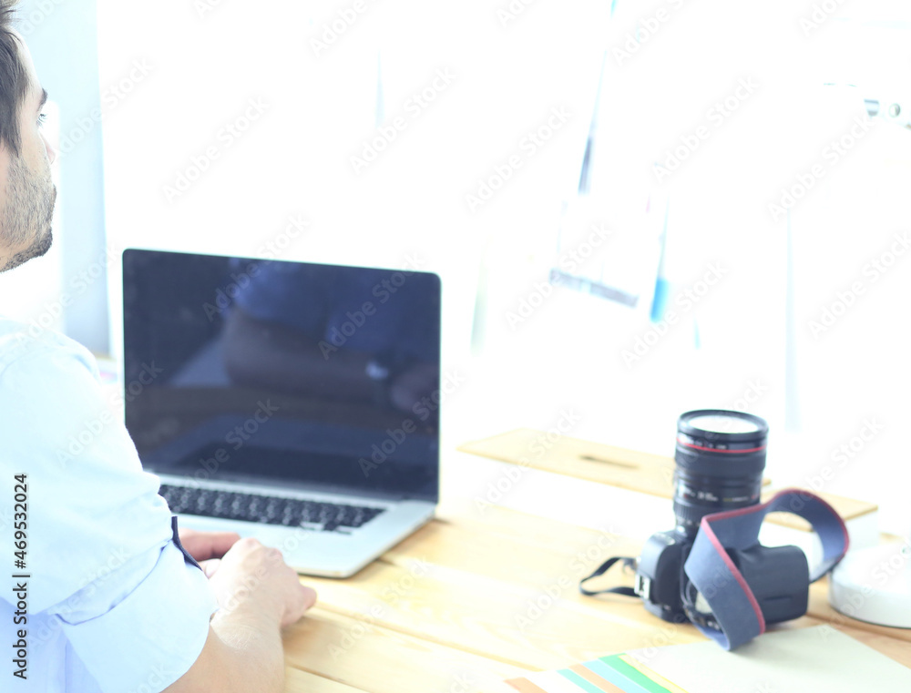 Poster portrait of young designer sitting at graphic studio in front of laptop and computer while working o