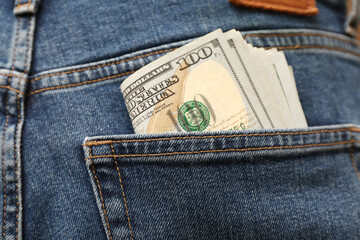 Dollar banknotes in pocket of jeans, closeup. Spending money