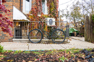 A retro style bicycle sits locked to a railing outside a 1930's building in Toronto's Beaches...