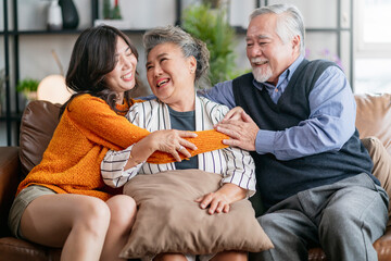 happiness asian family candid of daughter hug grandparent mother farther senior elder cozy relax on sofa couch surprise visiting in living room at home,together hug cheerful asian family at home