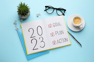 Flat lay composition of notebook with text 2023 Goal, Plan, Action on light blue background. New...