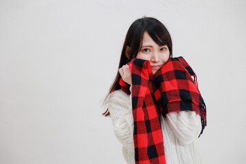 白い背景に赤いマフラーを身に着けている日本人女性