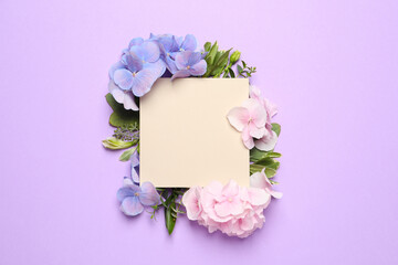 Beautiful hortensia flowers and blank card on violet background, flat lay. Space for text
