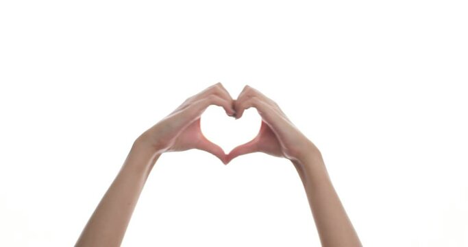 Close-up of a woman's hand shows a heart sign, like, good, class, everything is fine, to the music, on a white background, on a white screen. Signs, symbols and gestures.