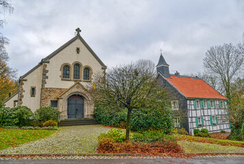 Fototapeta na wymiar Historische Kirche und Fachwerkhaus an der Abtsküche in Heiligenhaus