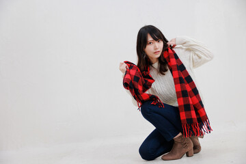 白い背景に赤いマフラーを身に着けている日本人女性