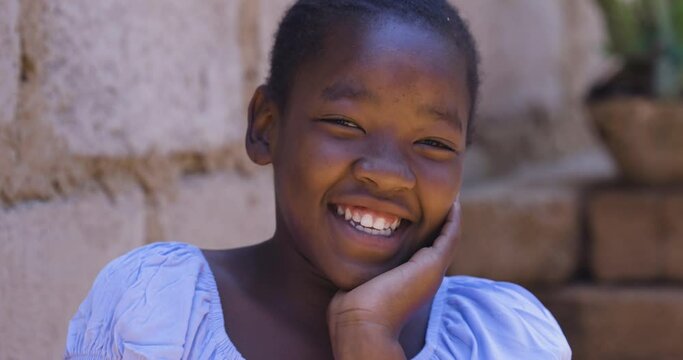 Poverty. Inequality. Portrait. Cute young Black African girl laughing and looking at camera