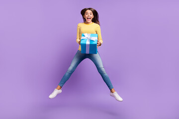 Fototapeta na wymiar Full length photo of young excited girl receive gift yell rejoice jumper isolated over purple color background