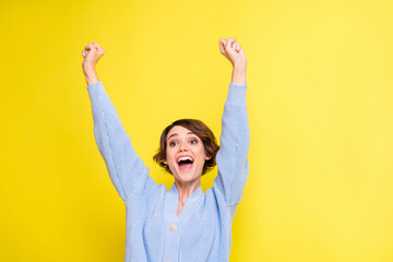 Photo of cheerful excited lady open mouth raise hands wear blue cardigan isolated yellow color...