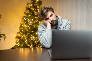 at night in the office a man sits in front of a computer on New Year's Eve