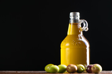 Olives and a bottle of olive oil over black