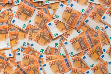 Fifty euros paper banknotes scattered on the table, top view as financial and business background